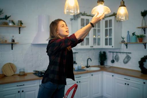 一个女人在房子里换灯泡.